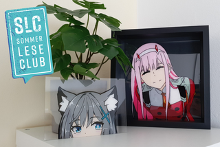 Auf einem weißen Schrank stehen zwei Bilder mit Anime-Figuren.