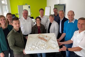 Teilnehmende des Workshops mit einem Modell des Gebäudes.