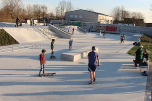 Das Bild zeigt Jugendliche auf einer Skateanlage.