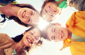 Das Bild zeigt eine Gruppe von lachenden Kindern und Jugendlichen.