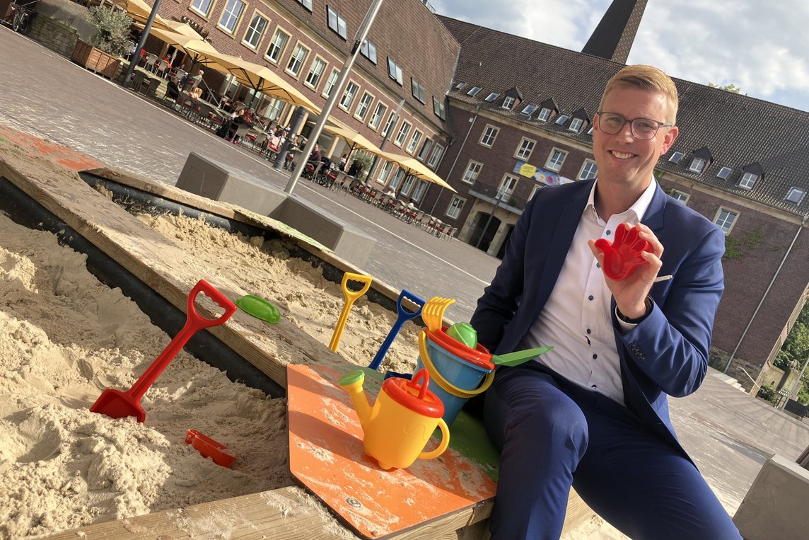 Bürgermeister Carsten Hövekamp hat den Sandkasten auf dem Marktplatz mit neuen Spielzeug ausgestattet. Foto: Stadt Dülmen/Siemes