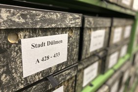 Das Foto zeigt beschriftete Archivboxen.