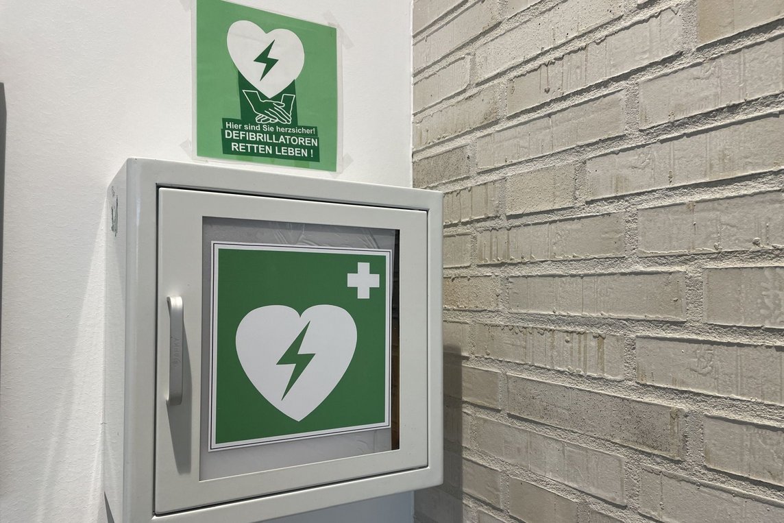Das Bild zeigt einen Defibrillator-Standort mit dem grün-weißen Herz-Symbol.
