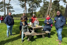 Das Foto zeigt Menschen an einem Picknick-Tisch