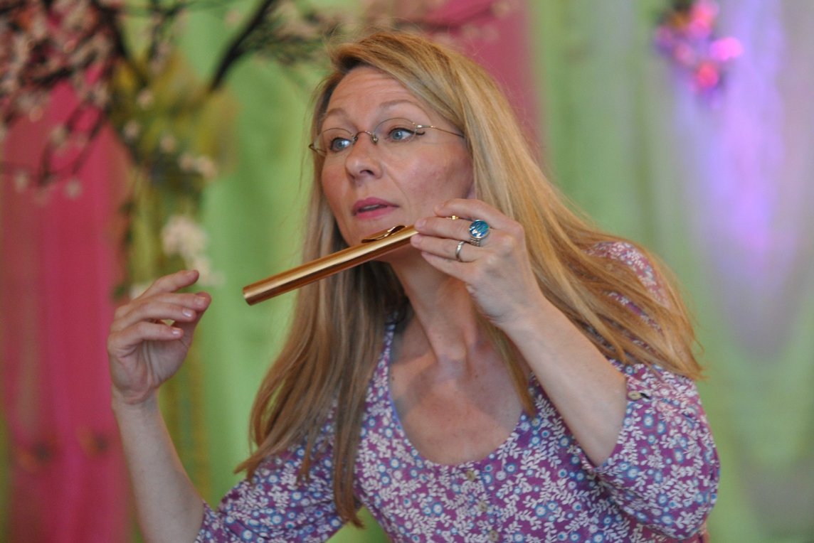 Dieses Bild zeigt eine Frau mit einer Flöte in der Hand.