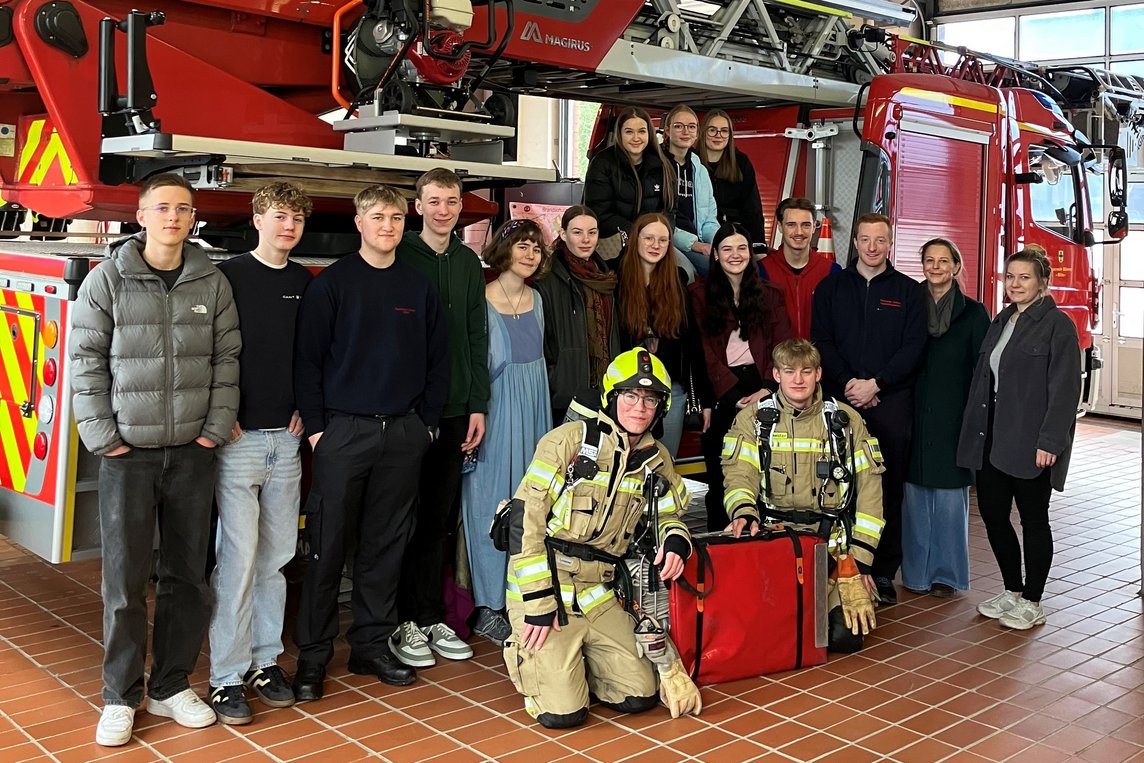 Das Foto zeigt die Gruppe vor einem Feuerwehrfahrzeug.