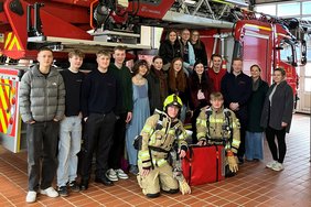 Das Foto zeigt die Gruppe vor einem Feuerwehrfahrzeug.