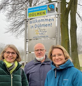 Freuen sich über die neuen Schilder, die an den Ortseingängen – hier: Lüdinghauser Straße – auf die Zertifizierung als „Fairtrade-Stadt“ hinweisen: Elvira Lipp (li.) und Helmut Tissen vom Vorstand des EineWeltLadens sowie VHS-Leiterin Dr. Marie Hologa.  Foto: Stadt Dülmen/Kannacher