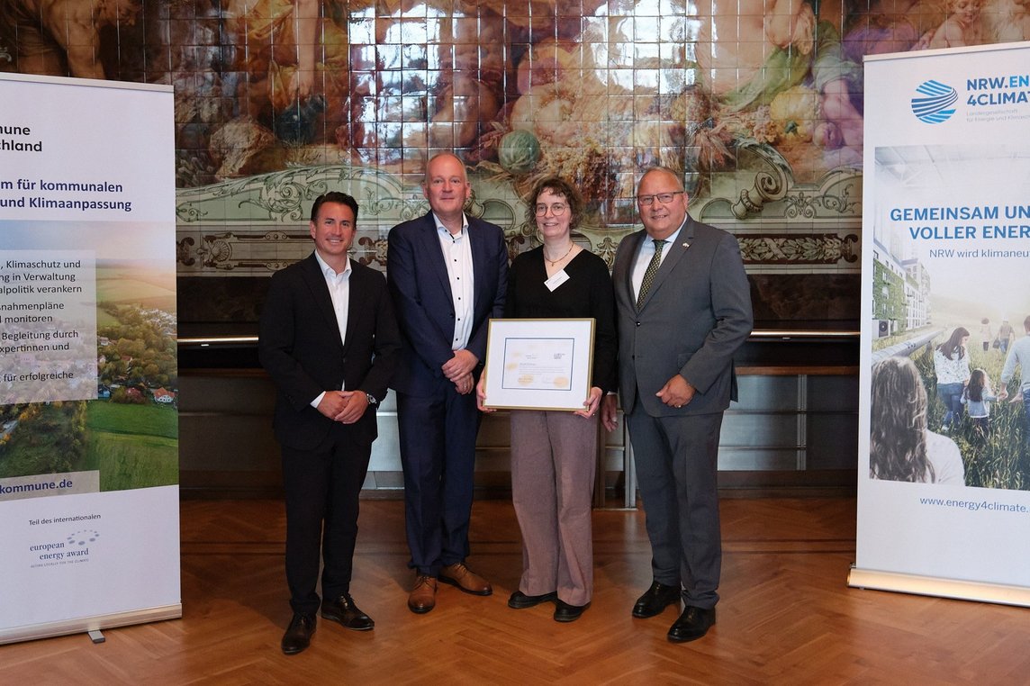 Josef Hovenjürgen, Parlamentarischer Staatssekretär im Ministerium für Heimat, Kommunales, Bau und Digitalisierung des Landes NRW (re.), und Christian Mildenberger, Geschäftsführer von NRW.Energy4Climate (li.), überreichten die Auszeichnung an Dülmens Klimaschutzmanagerin Carolin Dietrich und Reiner Tippkötter vom begleitenden Büro energielenker. Foto: Philip Lehmann, NRW.Energy4Climate