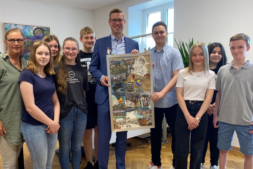 Schülerinnen und Schüler der Klasse 9A der Hermann-Leeser-Schule und ihre Lehrerin Dr. Andrea Peine (li.) übergaben die Collage als Leihgabe an Bürgermeister Carsten Hövekamp. Foto: Stadt Dülmen/Kannacher
