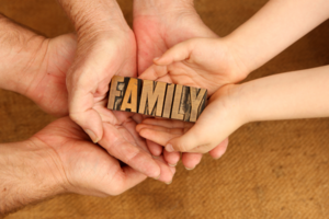 Viele Hände halten das Wort "Family".