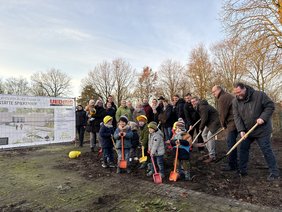 Gemeinsam mit Bürgermeister Carsten Hövekamp (3. v. re.) sowie zahlreichen weiteren Beteiligten setzten Kinder des Spiekerhof-Kindergartens den ersten Spatenstich für das neue Gebäude am Haferkamp 5. Foto: Stadt Dülmen/Kannacher